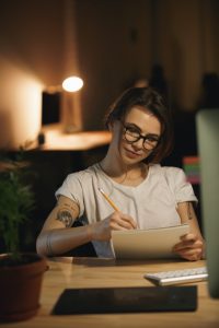 Escritorio de artista con libreta y portátil en un ambiente de luz cálida